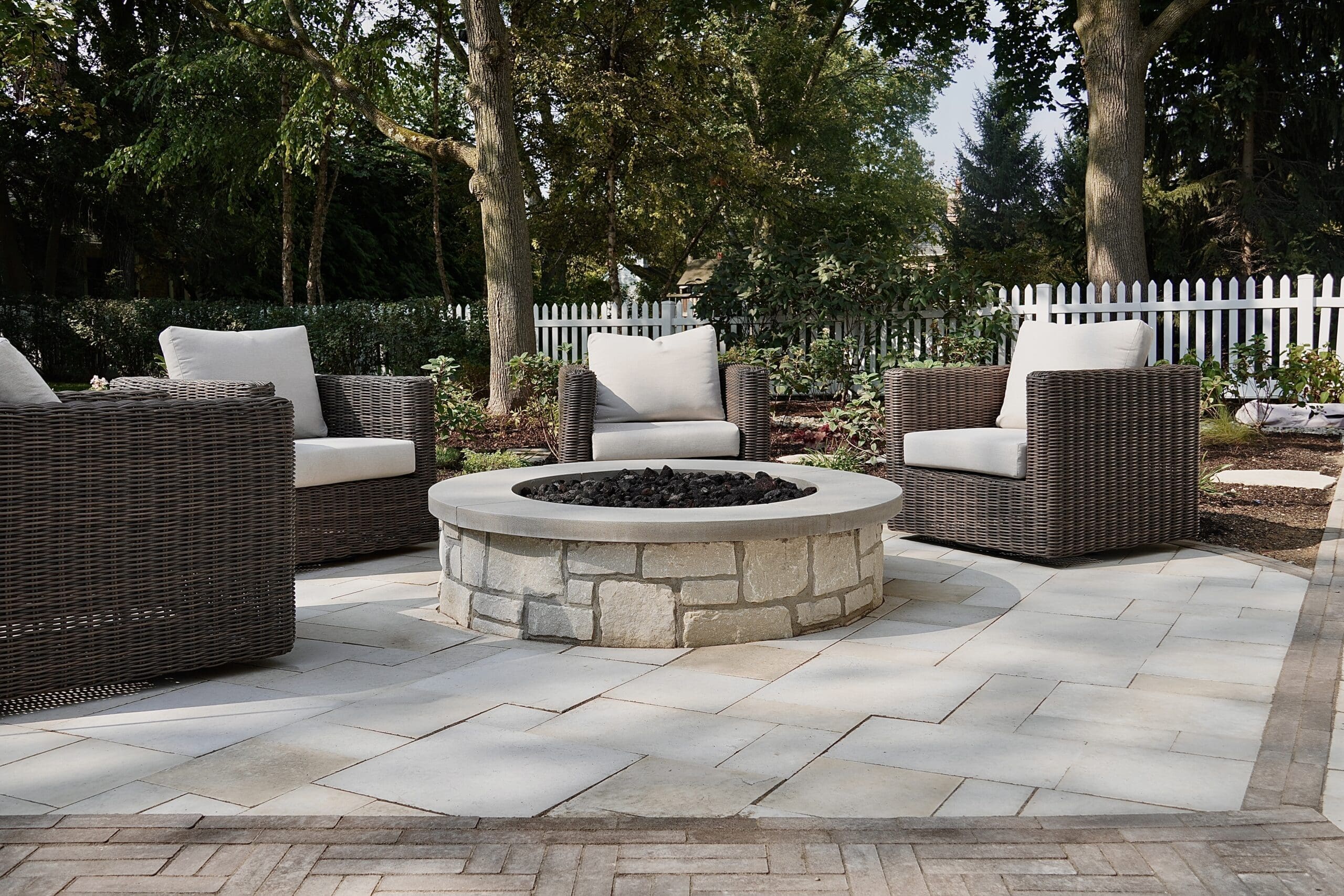 North Shore Paver Patio with Custom Fire Pit Custom paver patio with circular stone fire pit and lounge seating in a North Shore backyard.